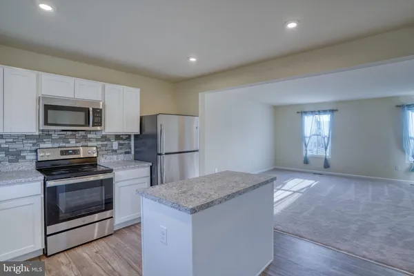 a kitchen with microwave a stove and refrigerator