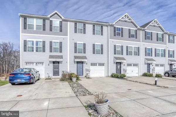 a front view of a building with a cars park side of a road