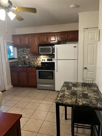 a kitchen with stainless steel appliances kitchen island granite countertop a refrigerator and a stove top oven