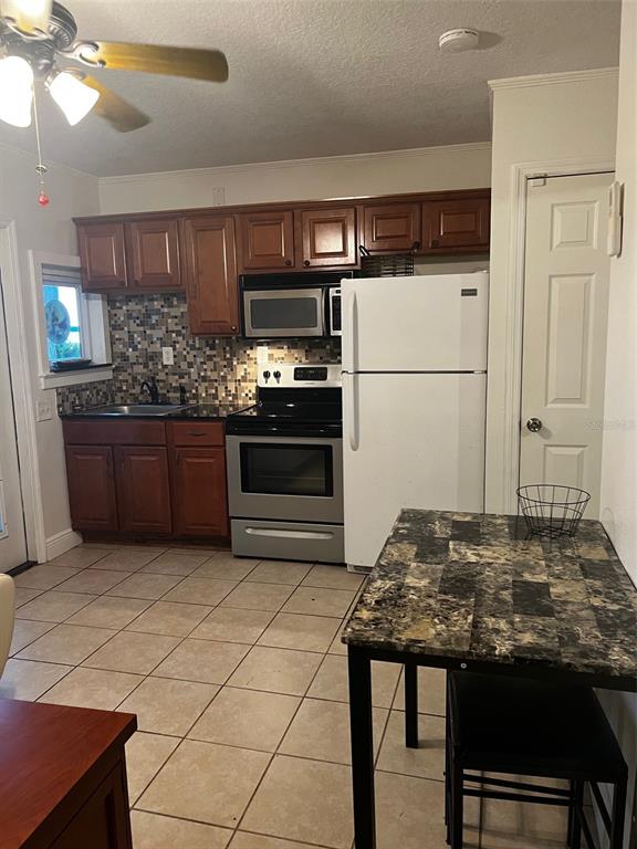 195 Mae Street, Unit A Eustis, FL 32726 - Photo 11 of 15 a kitchen with stainless steel appliances kitchen island granite countertop a refrigerator and a stove top oven
