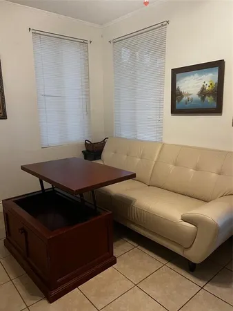 a living room with furniture and a air conditioner vent