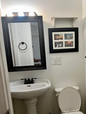 a bathroom with a toilet sink and mirror