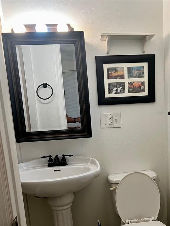 195 Mae Street, Unit A Eustis, FL 32726 - Photo 6 of 15 a bathroom with a toilet sink and mirror