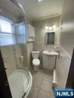 a bathroom with a granite countertop sink a toilet and a shower