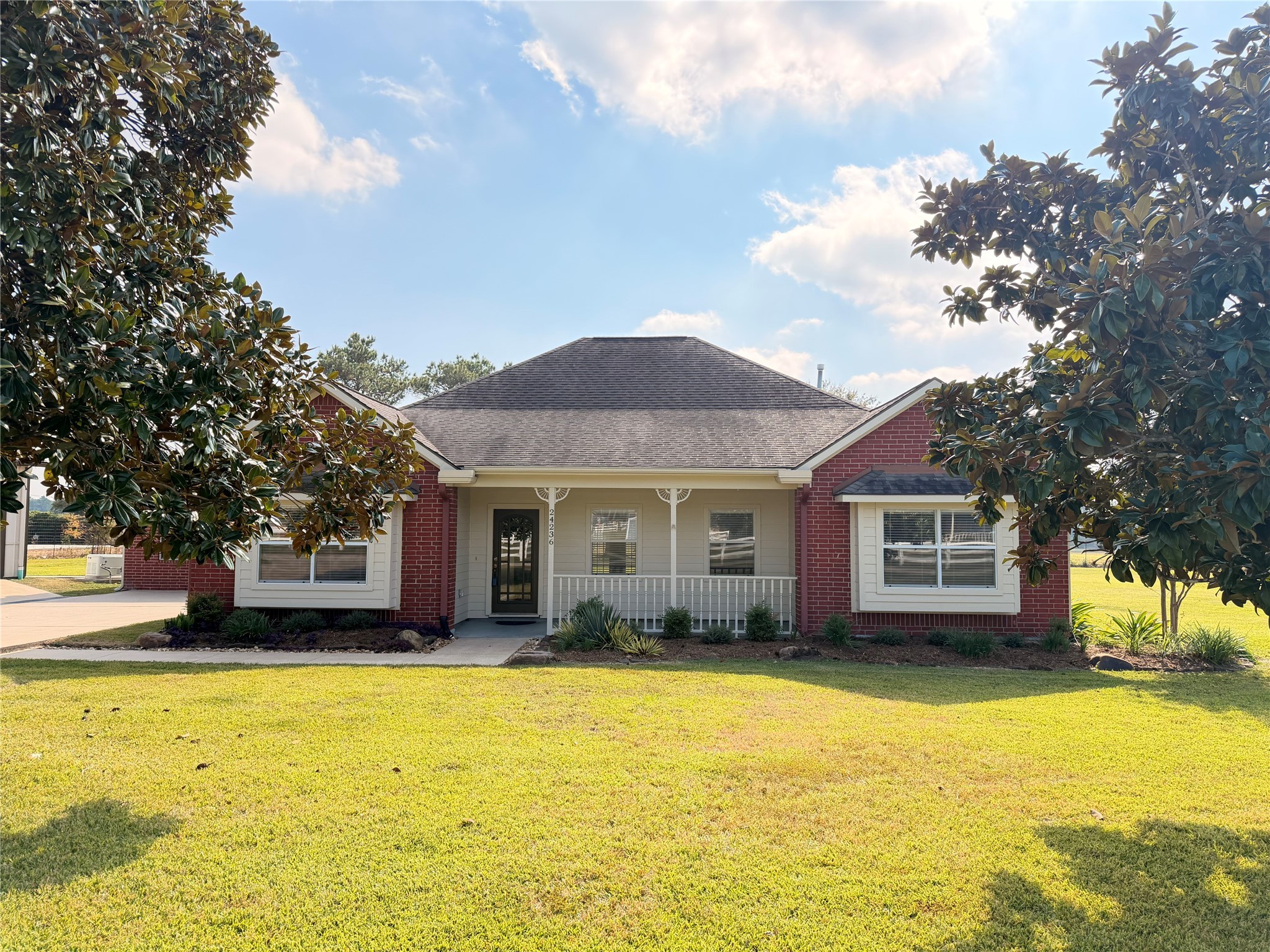 a front view of house with yard and trees around