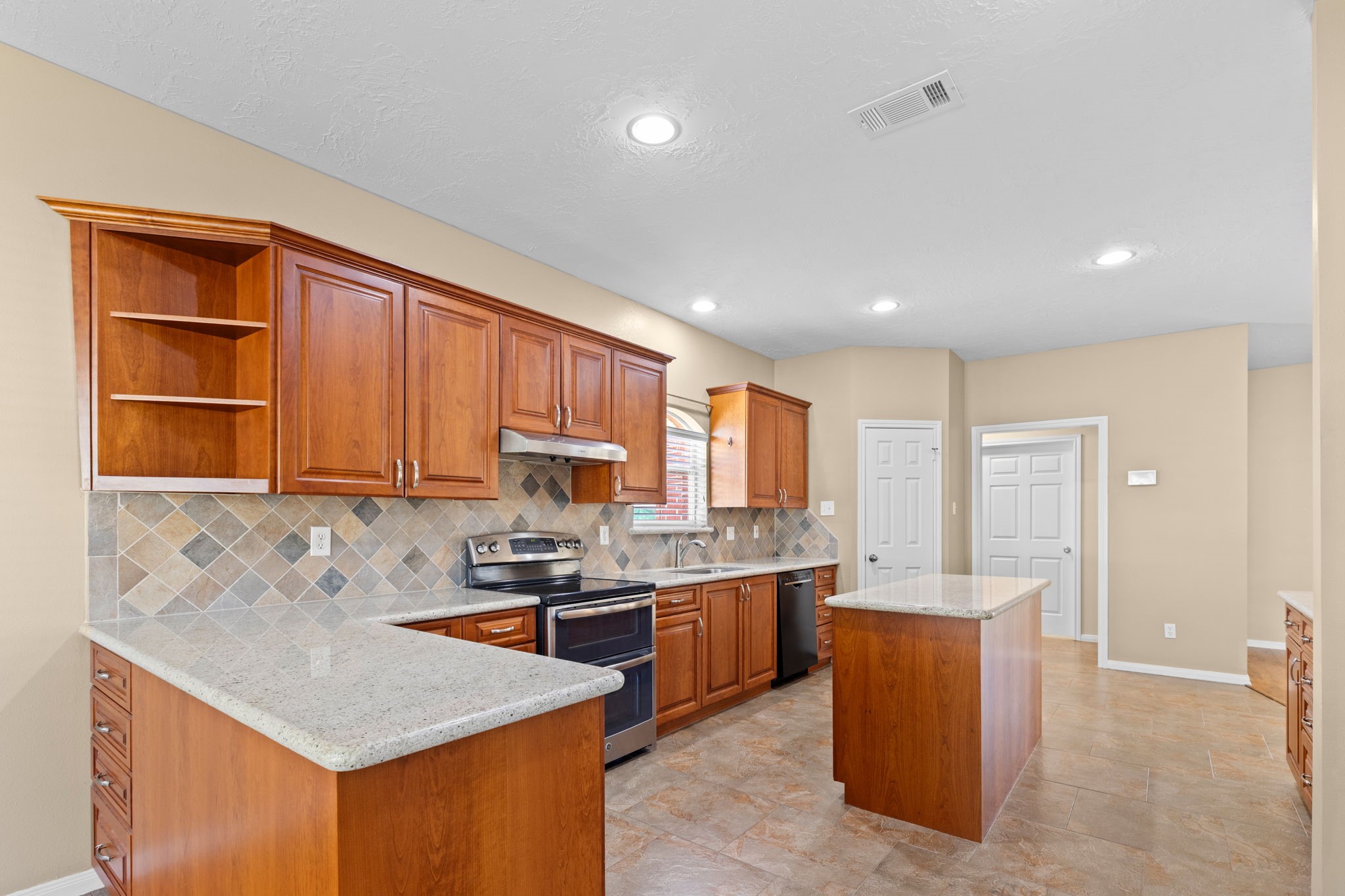 24236 Stuebner Airline Road Tomball, TX 77375 - Photo 10 of 39 a kitchen with stainless steel appliances granite countertop a sink stove and refrigerator