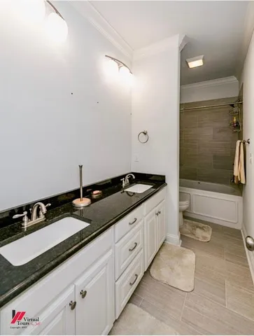 a spacious bathroom with a granite countertop sink and a bathtub