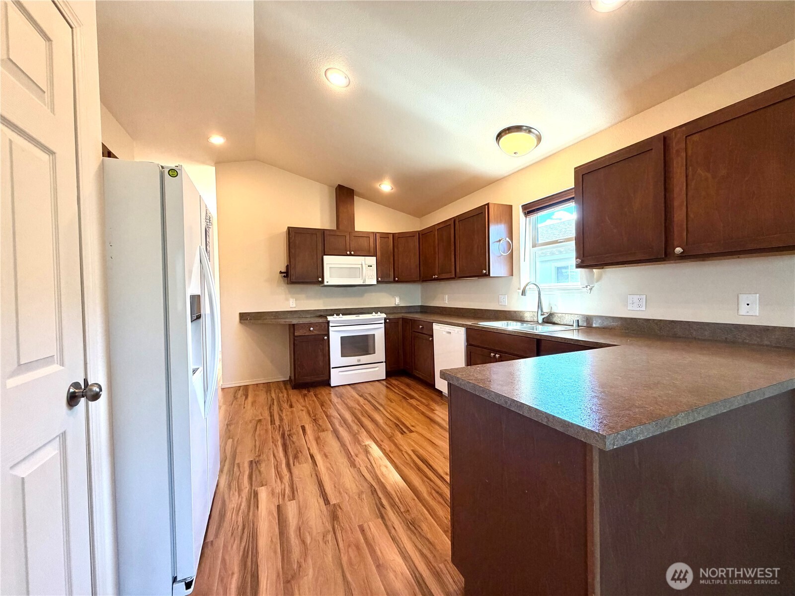 709 Paintbrush Lane Omak, WA 98841 - Photo 11 of 40 a kitchen with stainless steel appliances granite countertop a refrigerator a sink dishwasher a stove and a microwave oven on the blue kitchen countertops with wooden floor
