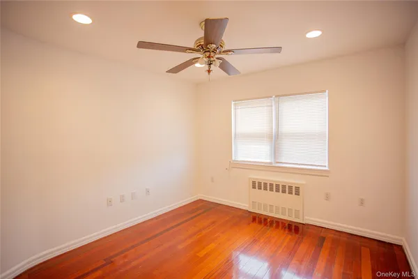 an empty room with a window and a ceiling fan