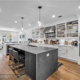 a kitchen with stainless steel appliances a table chairs refrigerator and cabinets