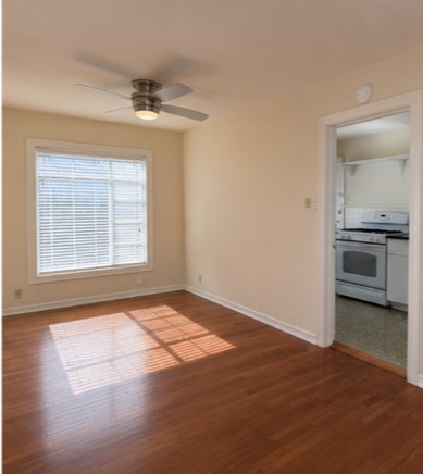 2509 Enfield Road, Unit A Austin, TX 78703 - Photo 3 of 6 Hardwood floors and a ceiling fan create a comfortable atmosphere, with a glimpse into the adjacent kitchen.