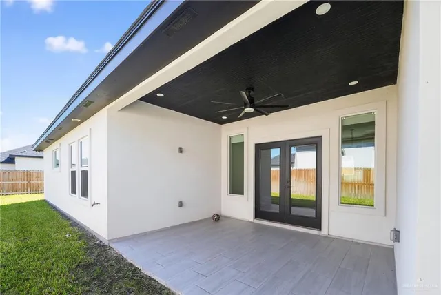 an empty room with window and ceiling fan