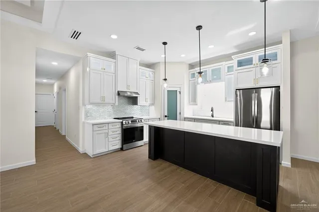 a kitchen that has a kitchen island hardwood floor and a ceiling fan