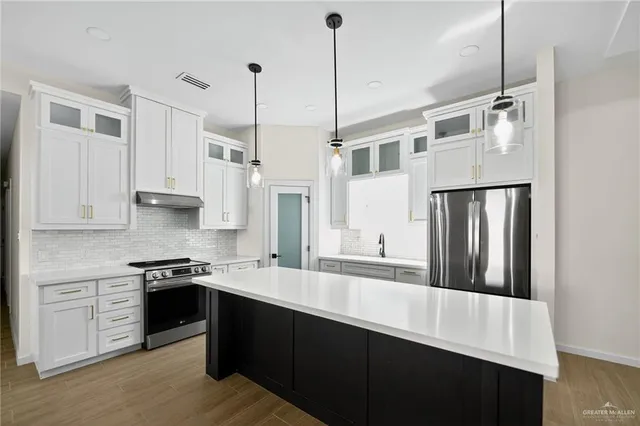 a kitchen with stainless steel appliances granite countertop a stove a sink and refrigerator