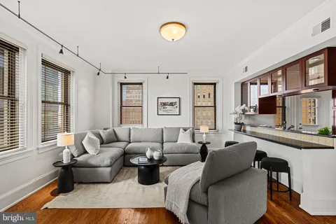 a living room with furniture a rug and kitchen view
