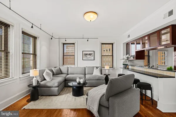 a living room with furniture a rug and kitchen view