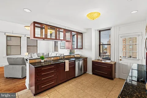a kitchen with granite countertop a refrigerator stove and cabinets