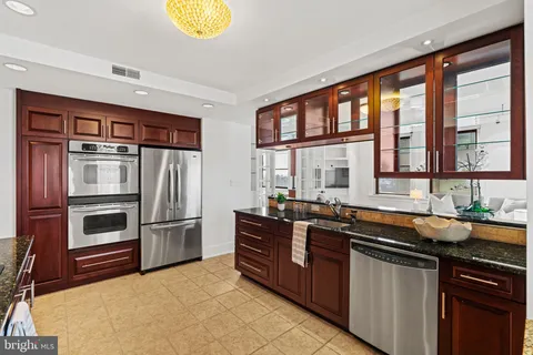 a kitchen with a stove a sink and a wooden cabinets
