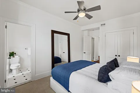 a bedroom with a bed couch and windows