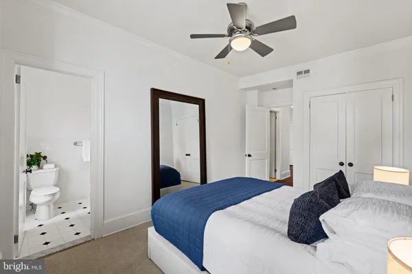a bedroom with a bed couch and windows