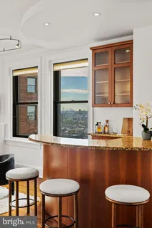 a bathroom with a toilet a sink a mirror and a window