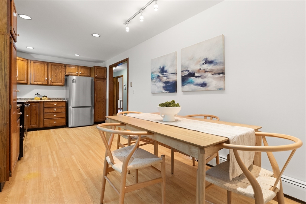 31 Kimball Road Amesbury, MA 01913 - Photo 8 of 40 a kitchen with stainless steel appliances kitchen island granite countertop a refrigerator a stove top oven and a dining table with wooden floor