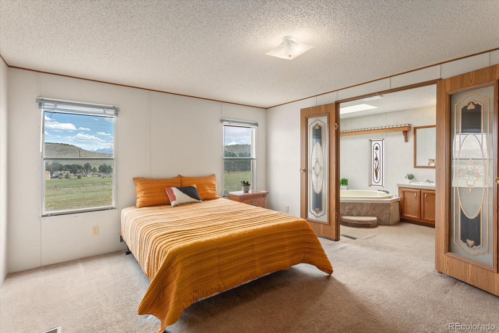 2275 K Path Cotopaxi, CO 81223 - Photo 9 of 28 a bedroom with a large bed and a chandelier