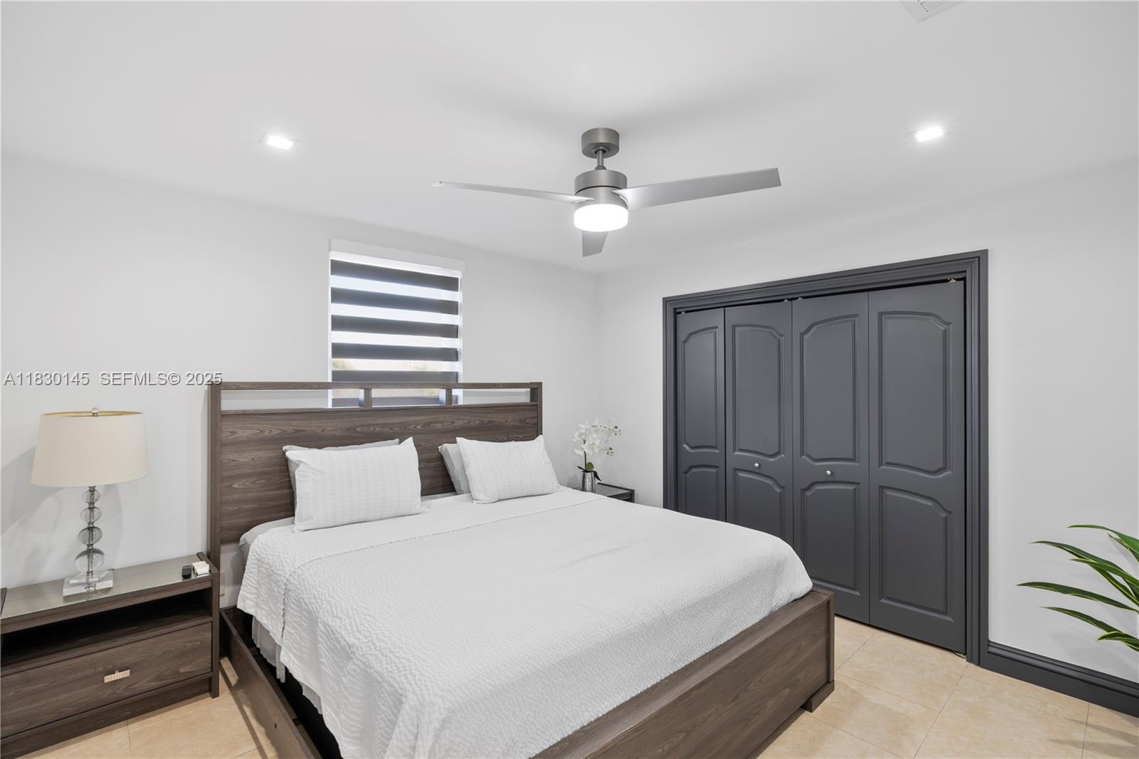 13815 Southwest 38th Street Miami, FL 33175 - Photo 28 of 75 a bedroom with a large bed and a chandelier