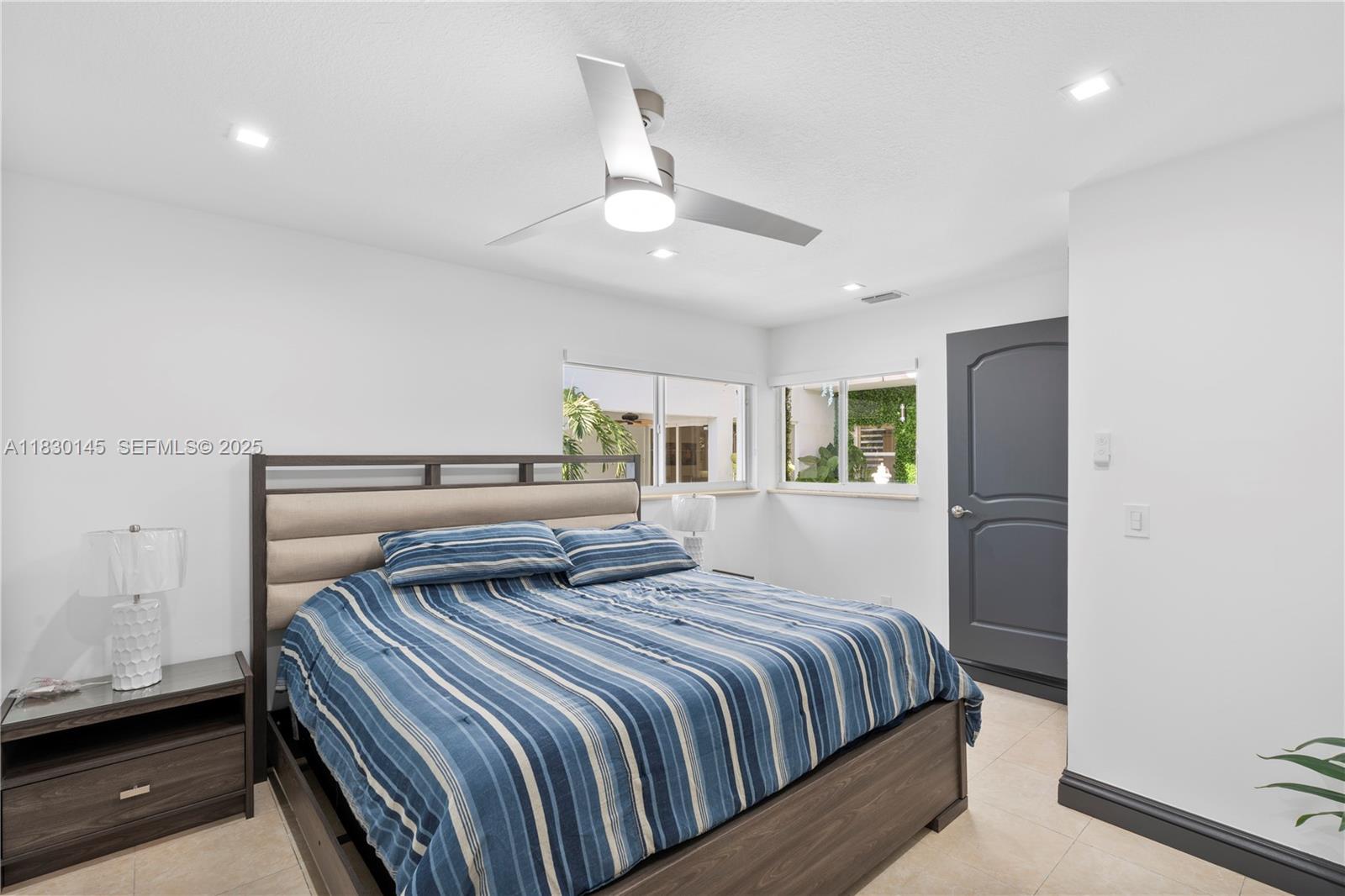 13815 Southwest 38th Street Miami, FL 33175 - Photo 34 of 75 a bedroom with a large bed and a chandelier