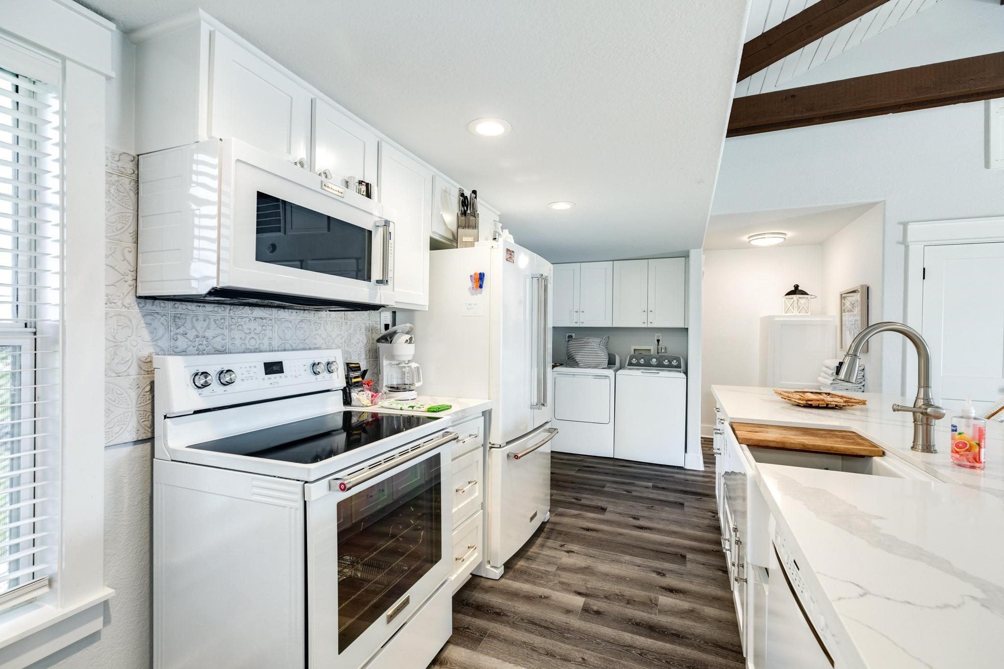 307 Angel Wing Street Surfside Beach, TX 77541 - Photo 6 of 23 a kitchen with white cabinets and stainless steel appliances