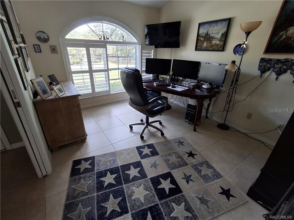 4295 North Bridge Road Beverly Hills, FL 34465 - Photo 13 of 79 a workspace with furniture and a flat screen tv