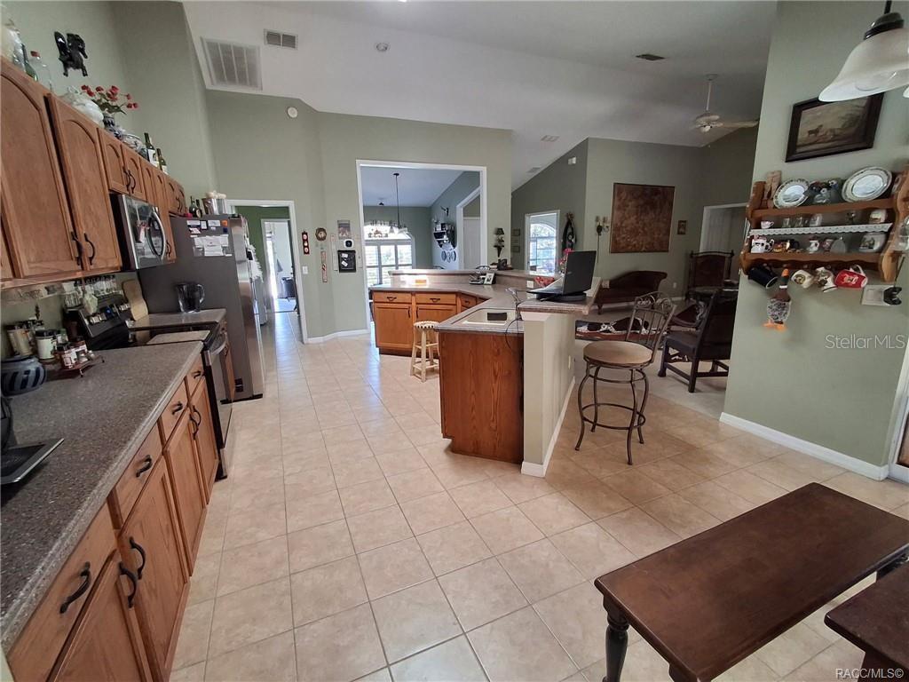 4295 North Bridge Road Beverly Hills, FL 34465 - Photo 7 of 79 a living room with furniture a flat screen tv and kitchen view