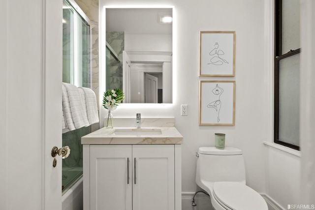 a bathroom with a toilet sink and mirror