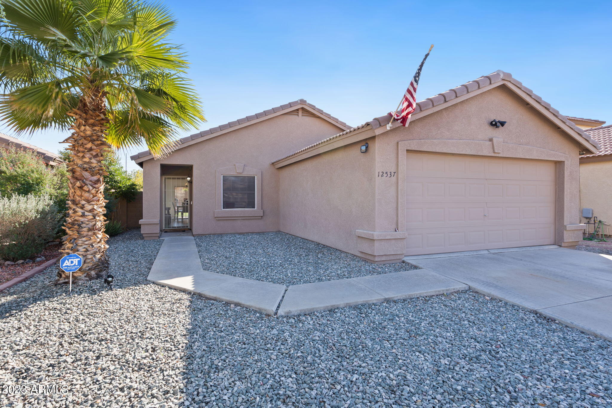 12537 West Bloomfield Road El Mirage, AZ 85335 - Photo 1 of 24 a front view of a house with a yard and garage