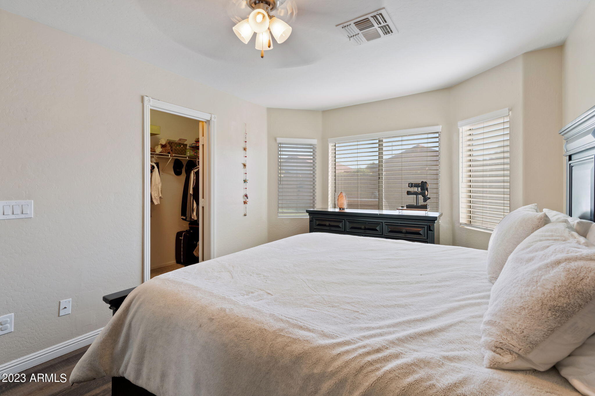 12537 West Bloomfield Road El Mirage, AZ 85335 - Photo 13 of 24 a bedroom with a large bed and a chandelier