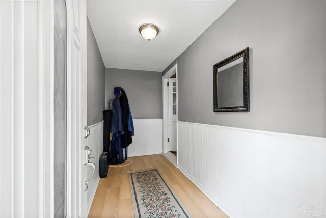 a view of a hallway with closet and wooden floor