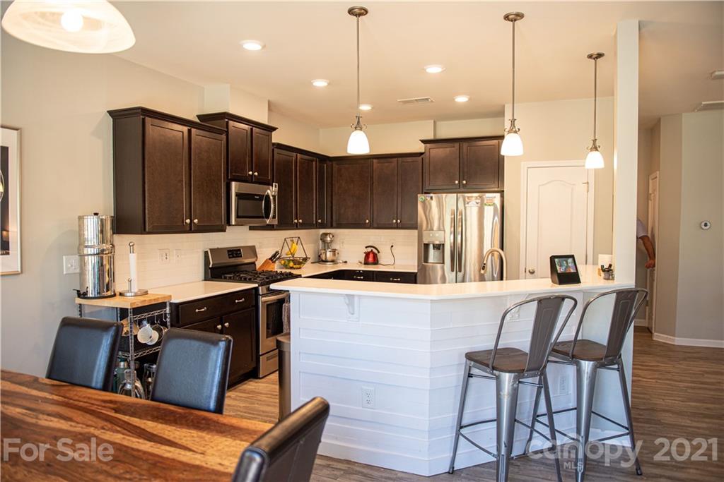 423 Triple Branch Trail Fort Mill, SC 29715 - Photo 8 of 29 a kitchen with stainless steel appliances granite countertop a refrigerator a sink dishwasher a stove kitchen island and chairs with wooden floor