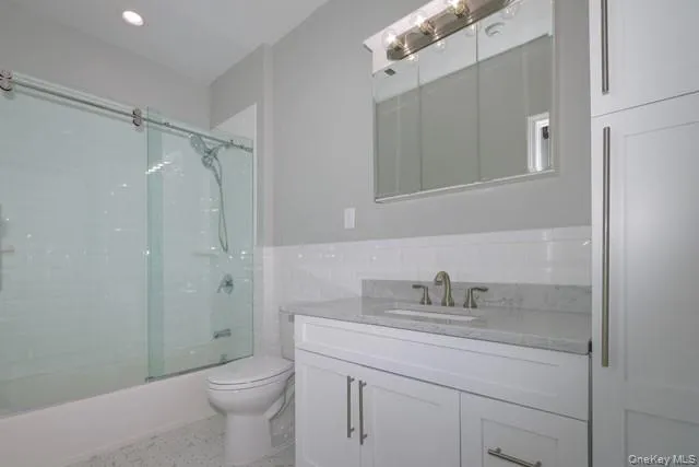 a bathroom with a sink toilet vanity and shower