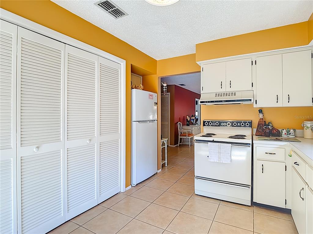 12924 Wedgewood Way, Unit D Hudson, FL 34667 - Photo 24 of 69 a kitchen with a refrigerator a stove top oven and cabinets