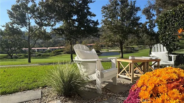 a view of a patio with table and chairs potted plants and large tree