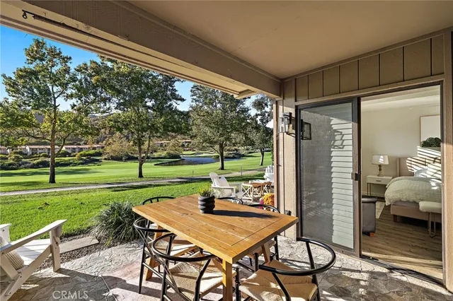 a view of a patio with a table chairs and a backyard