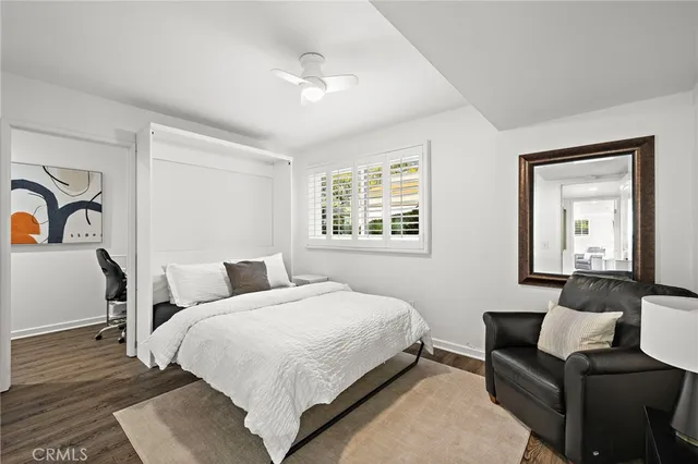a bedroom with a bed wooden floor and lamp