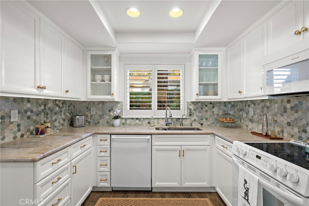 31421 East Nine Drive, Unit 79A Laguna Niguel, CA 92677 - Photo 4 of 31 a kitchen with granite countertop white cabinets and white appliances