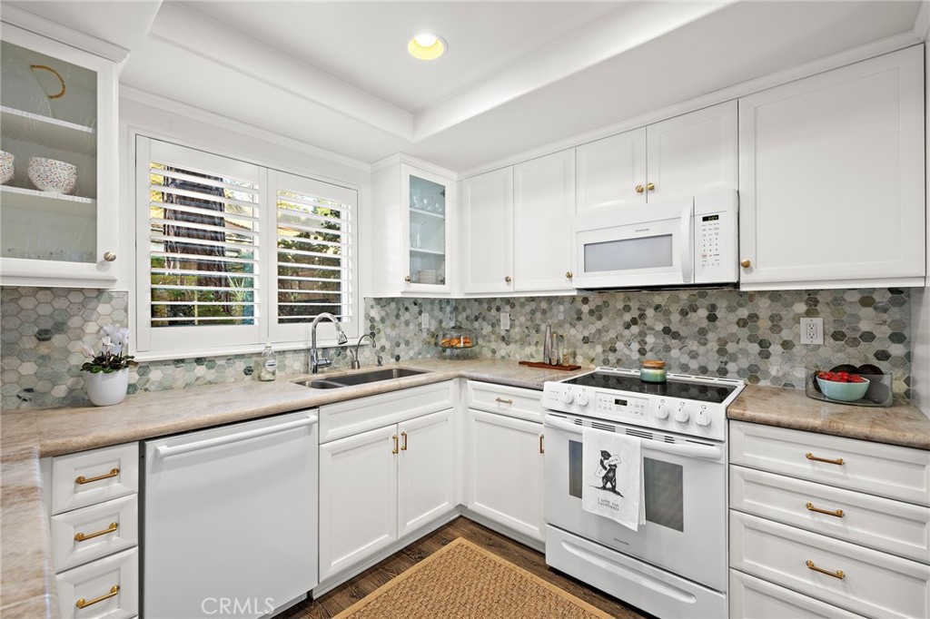 31421 East Nine Drive, Unit 79A Laguna Niguel, CA 92677 - Photo 5 of 31 a kitchen with white cabinets appliances a sink and a window