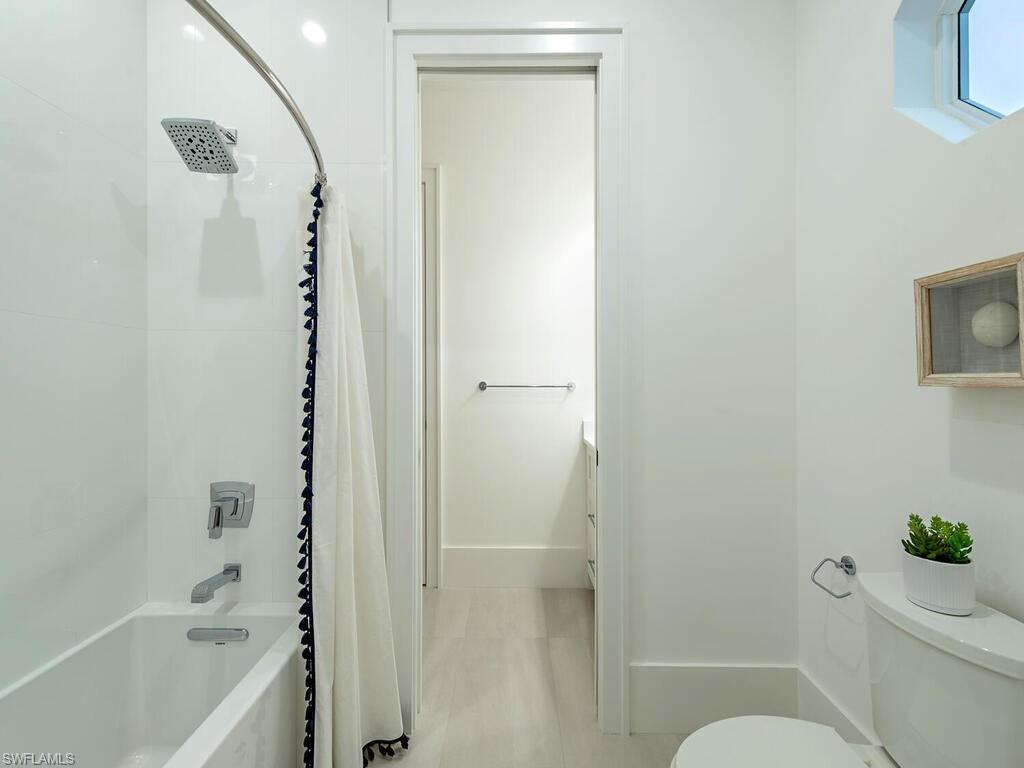 282 Bahia Point Naples, FL 34103 - Photo 23 of 38 a bathroom with a shower curtain a sink and a toilet