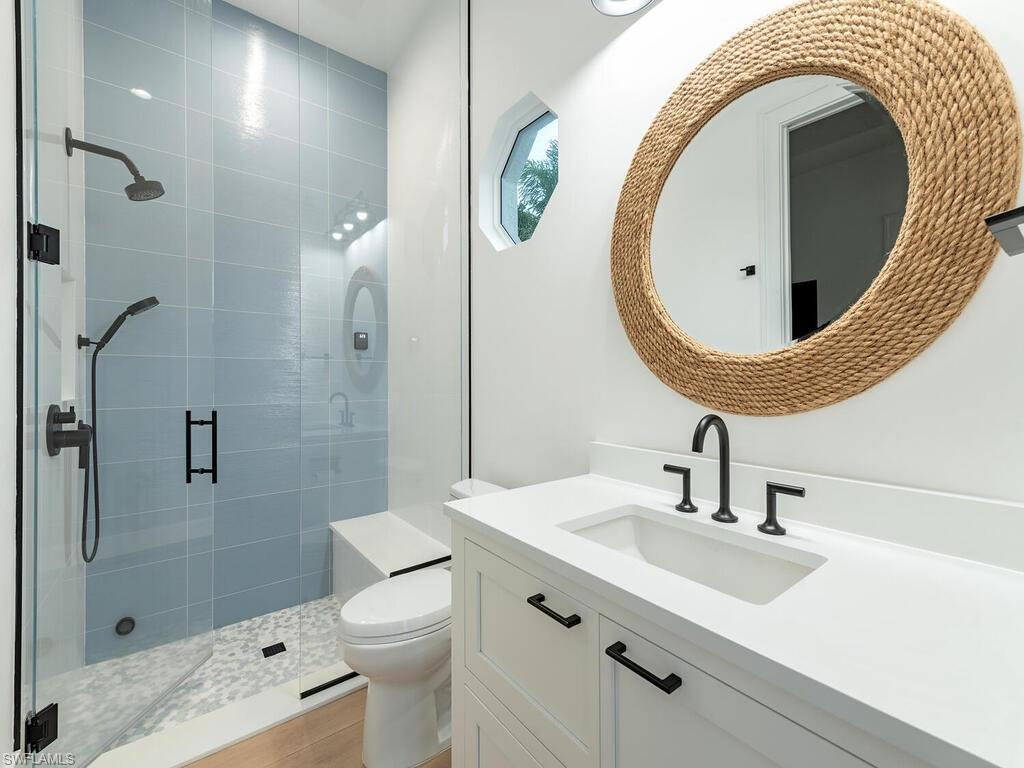 282 Bahia Point Naples, FL 34103 - Photo 27 of 38 a bathroom with a sink a toilet and a mirror