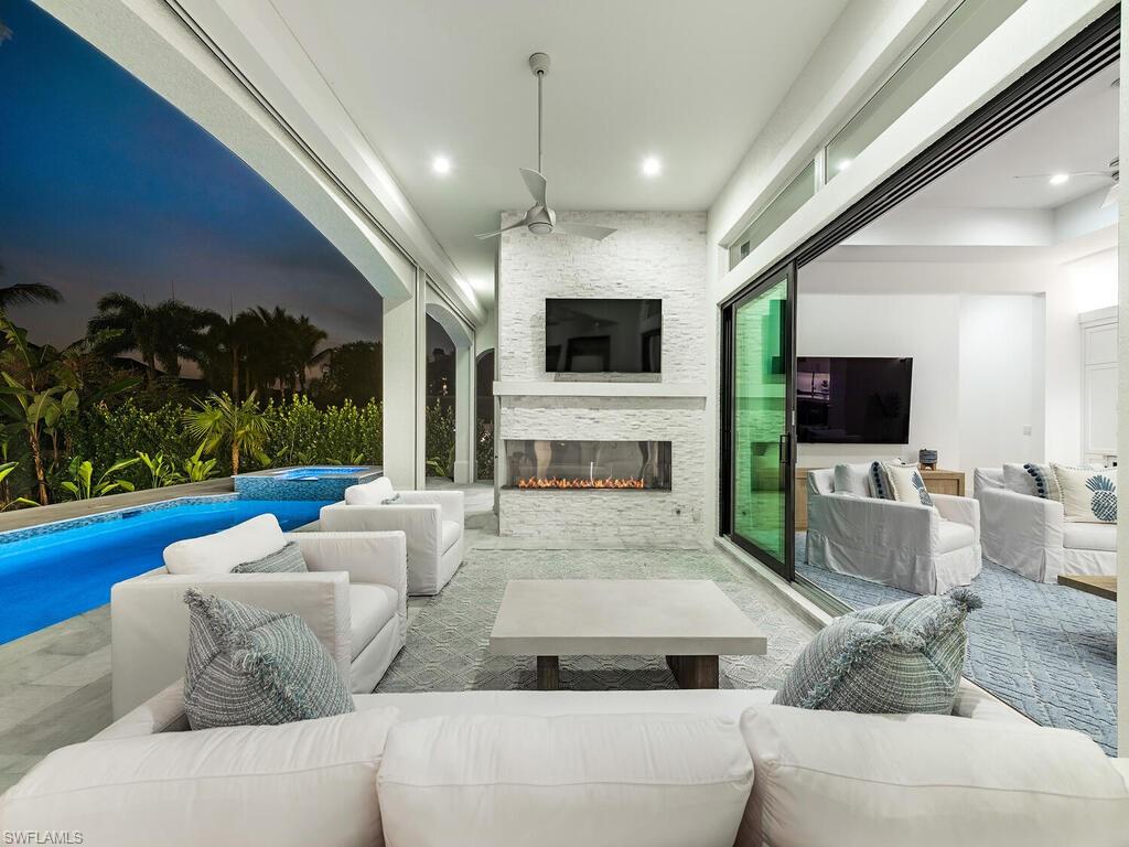 282 Bahia Point Naples, FL 34103 - Photo 3 of 38 a living room with furniture a flat screen tv and a fireplace