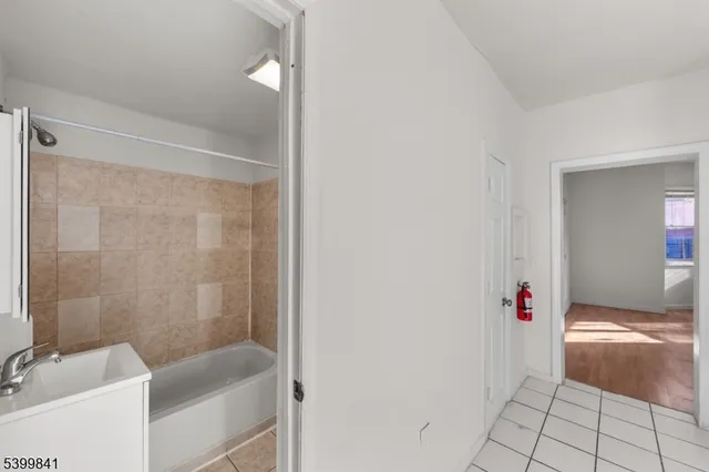 a bathroom with a tub shower and a sink