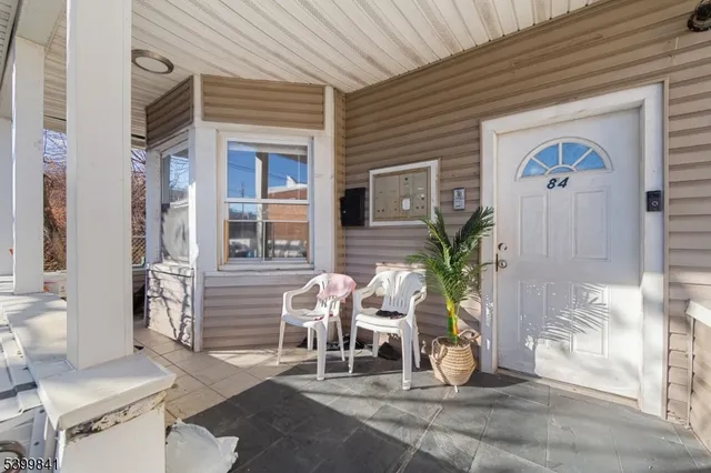 a view of a porch with chairs and potted plants