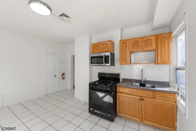 a kitchen with stainless steel appliances a sink stove and cabinets